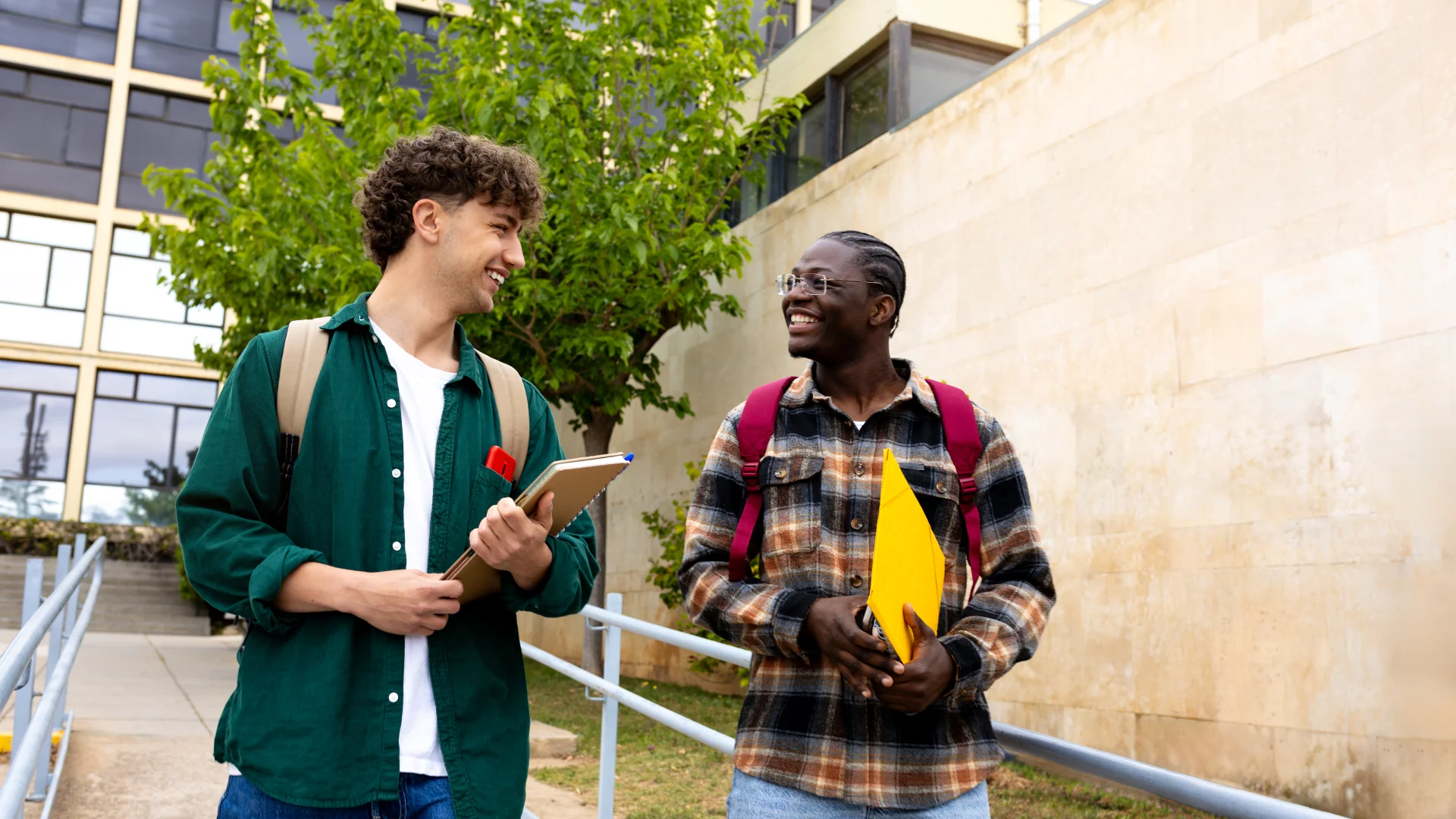 Estudantes universitários diversos conversando alegremente enquanto caminham pelo campus durante o dia para ilustrar vida acadêmica