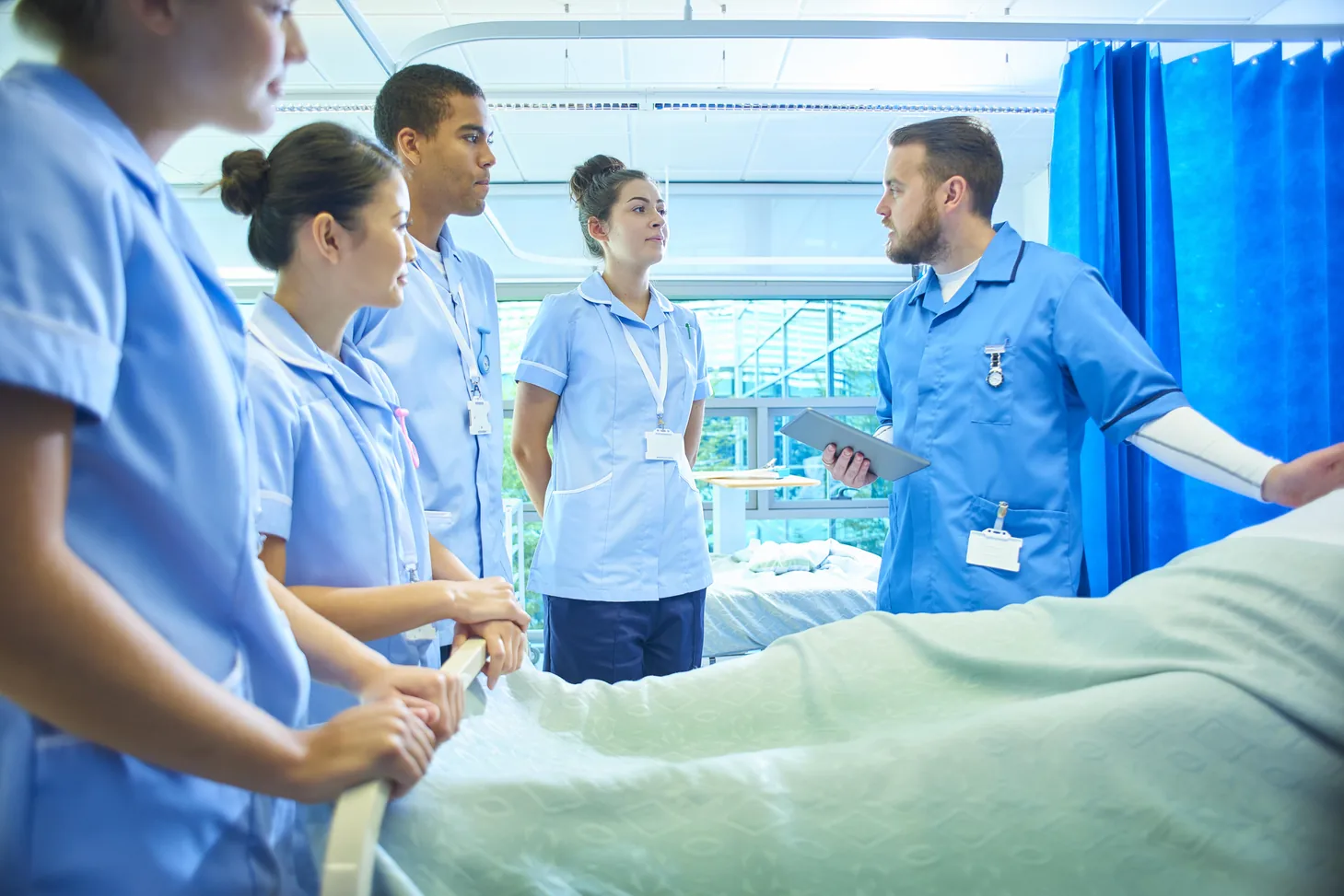 Estudantes de enfermagem e enfermeiro mentor em treinamento prático em hospital