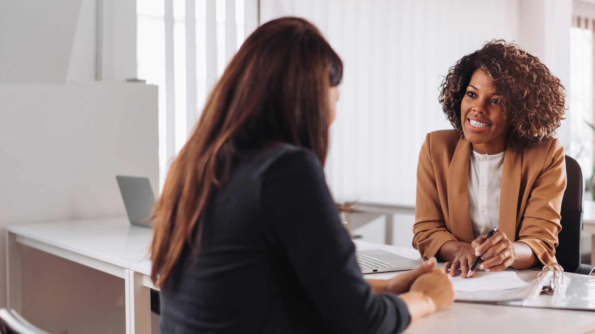 Duas mulheres profissionais colaborando em uma reunião de negócios produtiva no ambiente de escritório corporativo