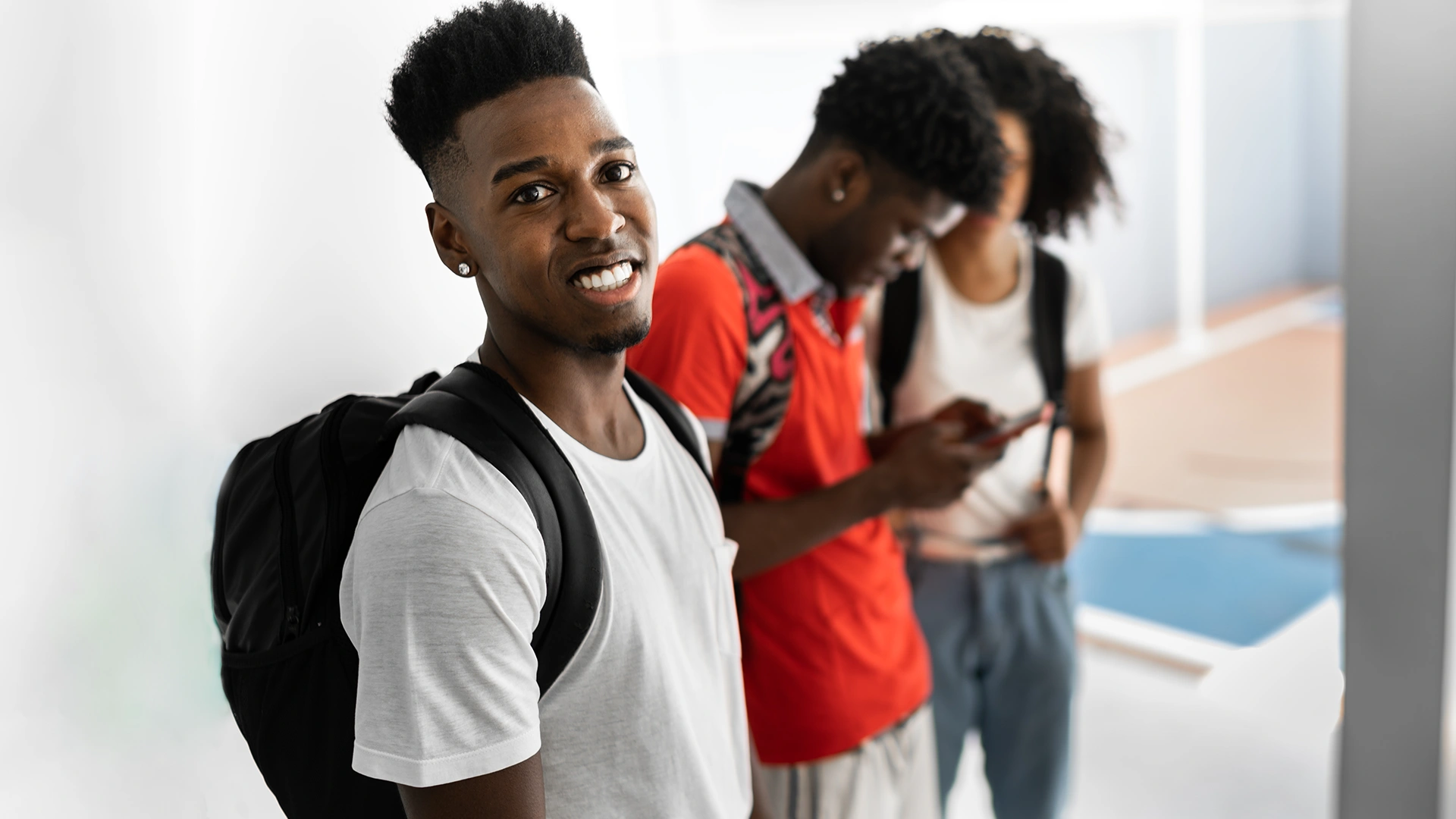 Estudante jovem sorrindo em um campus universitário com outros colegas ao fundo