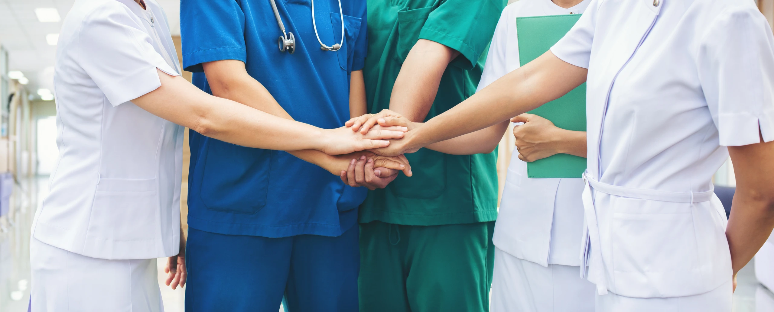 Equipe médica unida com as mãos juntas em sinal de colaboração no hospital