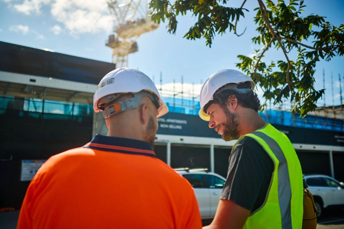 Estagiários e profissionais de engenharia civil colaborando em um canteiro de obras para aprendizado prático