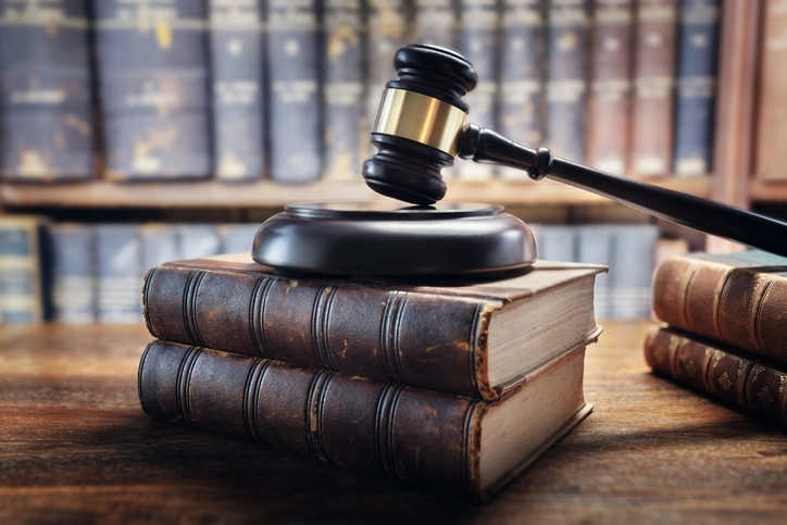 Martelo de juiz e livros jurídicos representando a justiça e o curso de direito para estudantes e profissionais Martelo de juiz sobre livros de direito em uma biblioteca
