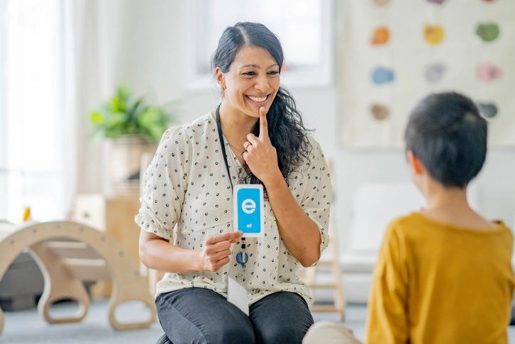 Atendimento de fonoaudiologia infantil no IBMR com técnicas de estimulação da fala e linguagem Fonoaudióloga realizando atendimento terapêutico com criança usando cartão de letra