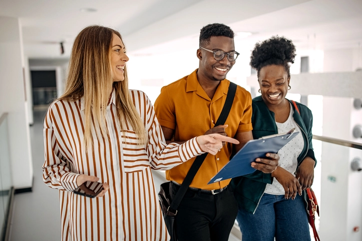 Estudantes universitários sorridentes colaborando em um projeto de estágio no IBMR
