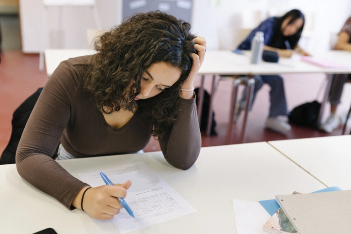 Estudante concentrada fazendo prova ou exercício em sala de aula