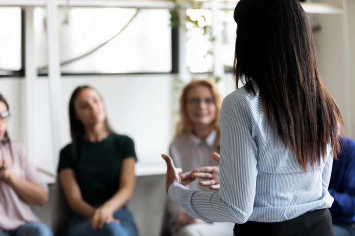 Atendimento psicológico e dinâmica de grupo na Clínica Escola do IBMR para estudantes e comunidade Psicóloga conduzindo sessão de terapia de grupo em clínica escola