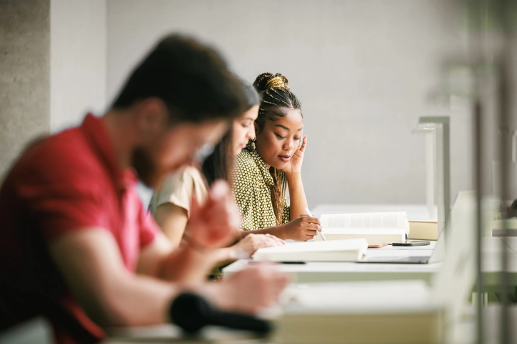 Estudantes concentrados estudando em uma biblioteca da UniBH