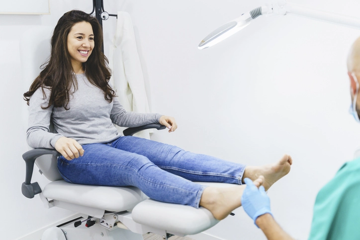 Paciente sorrindo durante consulta de podologia em clínica especializada