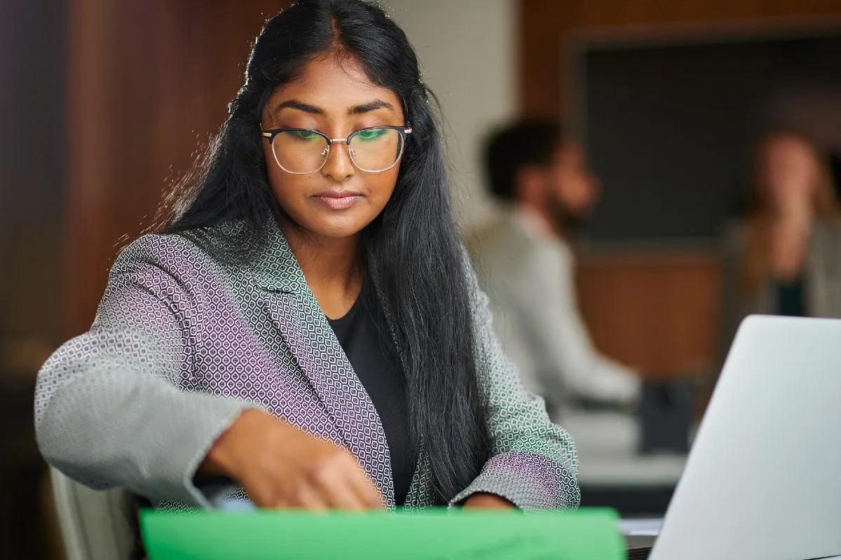 Descubra como é a rotina e o curso de graduação em Direito com esta estudante analisando materiais de estudo