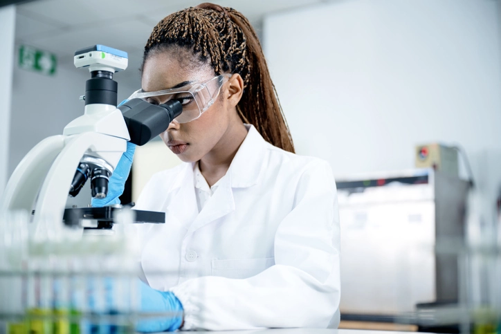 Estudante de ciências da saúde usando microscópio em laboratório acadêmico