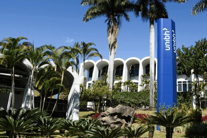 Fachada do campus universitário do UniBH com palmeiras e totem de identificação