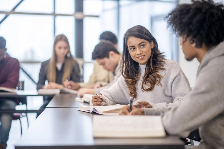 Estudantes universitários diversos colaborando e estudando juntos em uma sala de aula