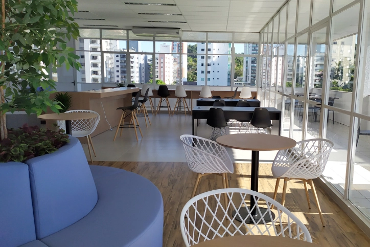 Espaço de convivência e estudos com design moderno, iluminação natural e vista urbana para ambientes corporativos e acadêmicos