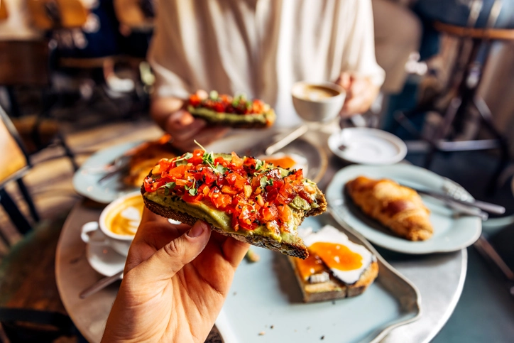 https://estaticos.animaeducacao.com.br/medias/20251009170643/GettyImages-1793268004.webp Café da manhã saudável com torrada de abacate e tomate em uma cafeteria charmosa para começar bem o dia