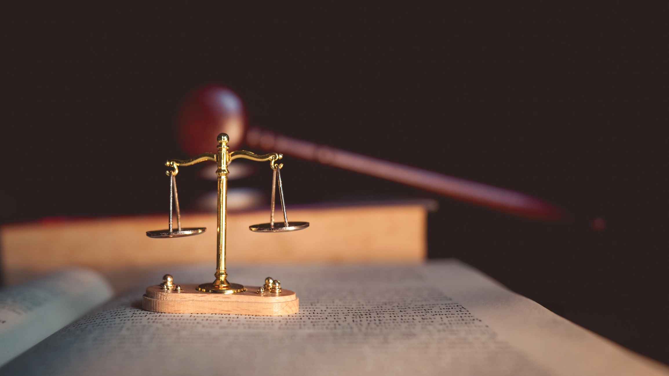 Balança da justiça e martelo de juiz sobre livros de direito representando o sistema judiciário e advocacia