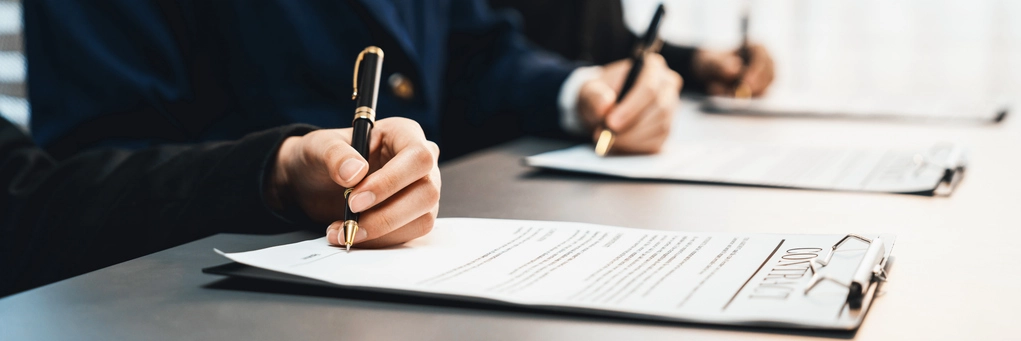 Pessoas assinando um contrato formal em uma mesa de escritório