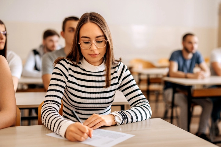 Estudante focada fazendo uma prova em sala de aula