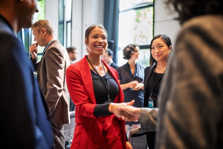 Mulher de negócios sorridente cumprimentando colega em evento corporativo