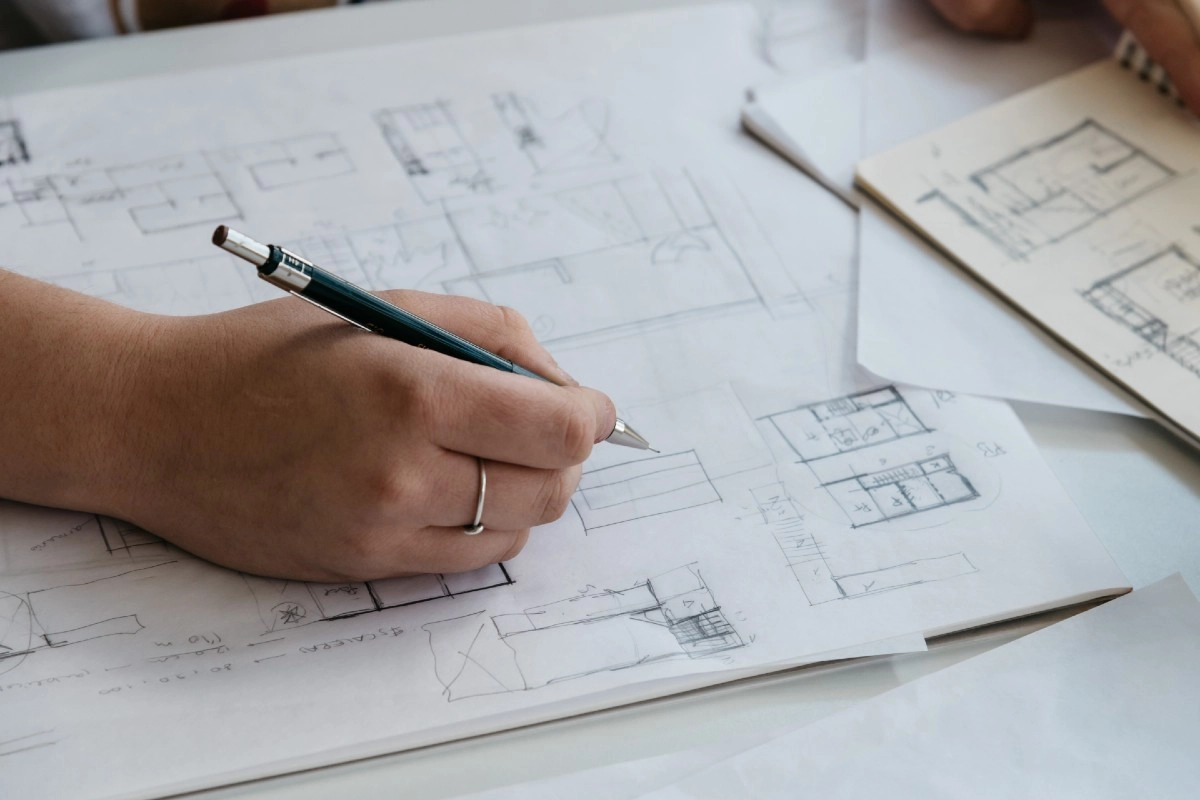 Arquiteta desenhando planta baixa de um projeto arquitetônico à mão