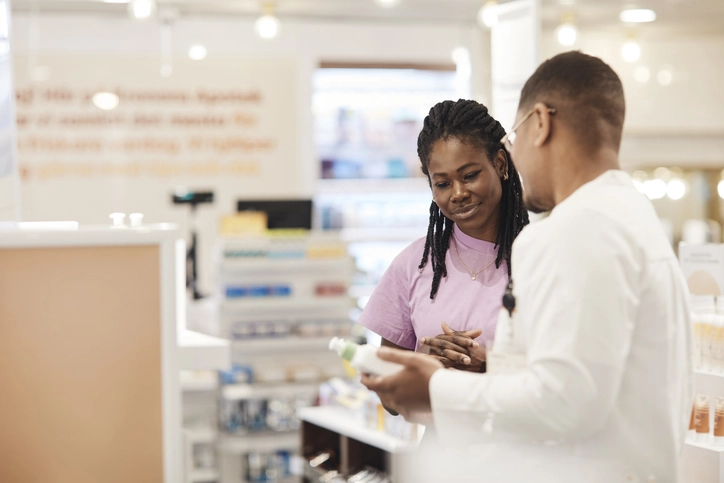 Farmacêutico oferecendo orientação especializada sobre produtos de saúde e cuidados pessoais em uma farmácia moderna Farmacêutico prestando atendimento a uma cliente em uma drogaria