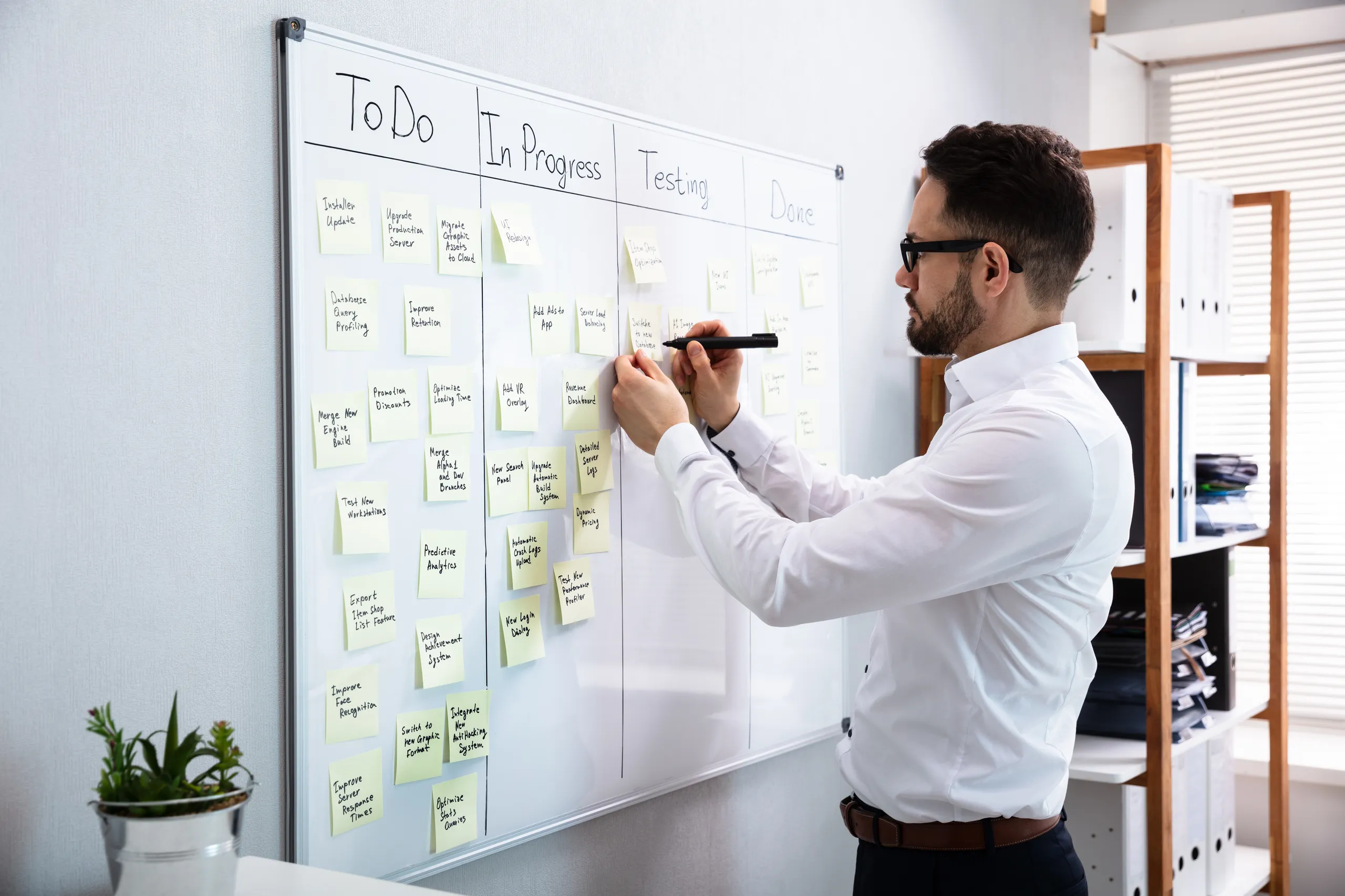 Profissional organizando tarefas em um quadro Kanban no escritório