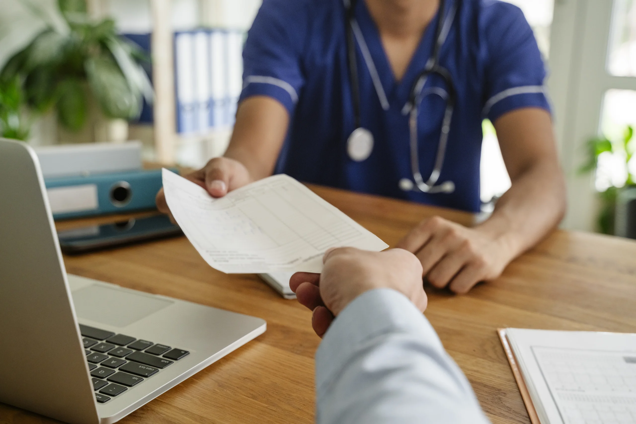 Médico do trabalho entregando um documento ou atestado para um paciente em um consultório