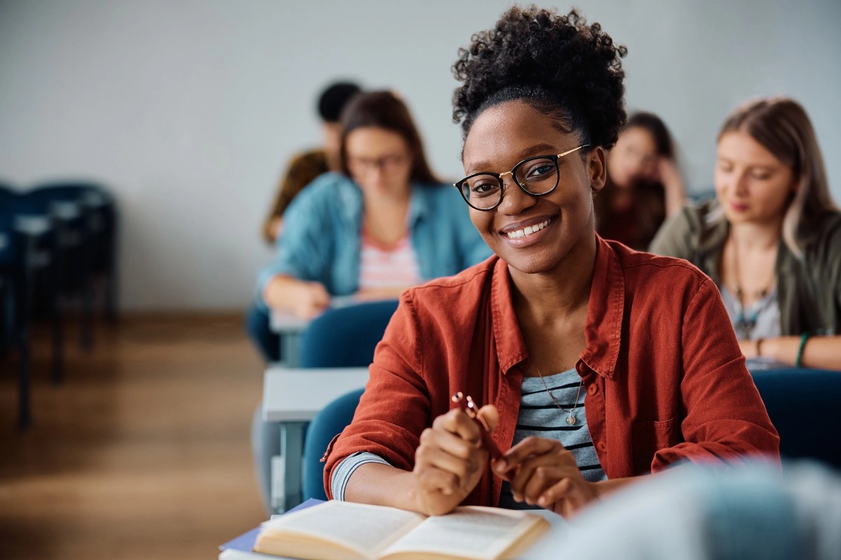 Estudante sorridente em sala de aula estudando para o ENEM