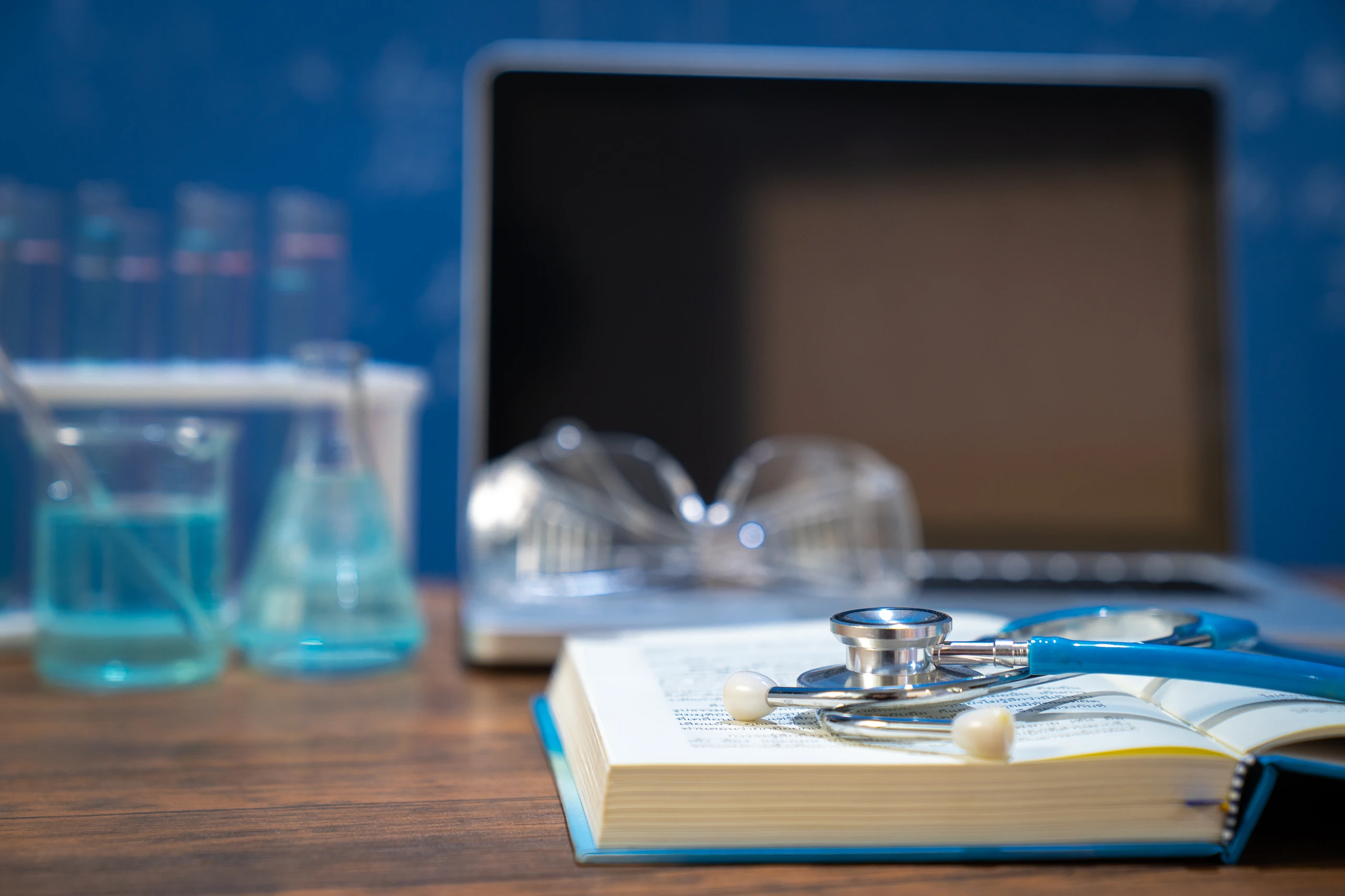 Estetoscópio sobre livro aberto em mesa de laboratório de medicina