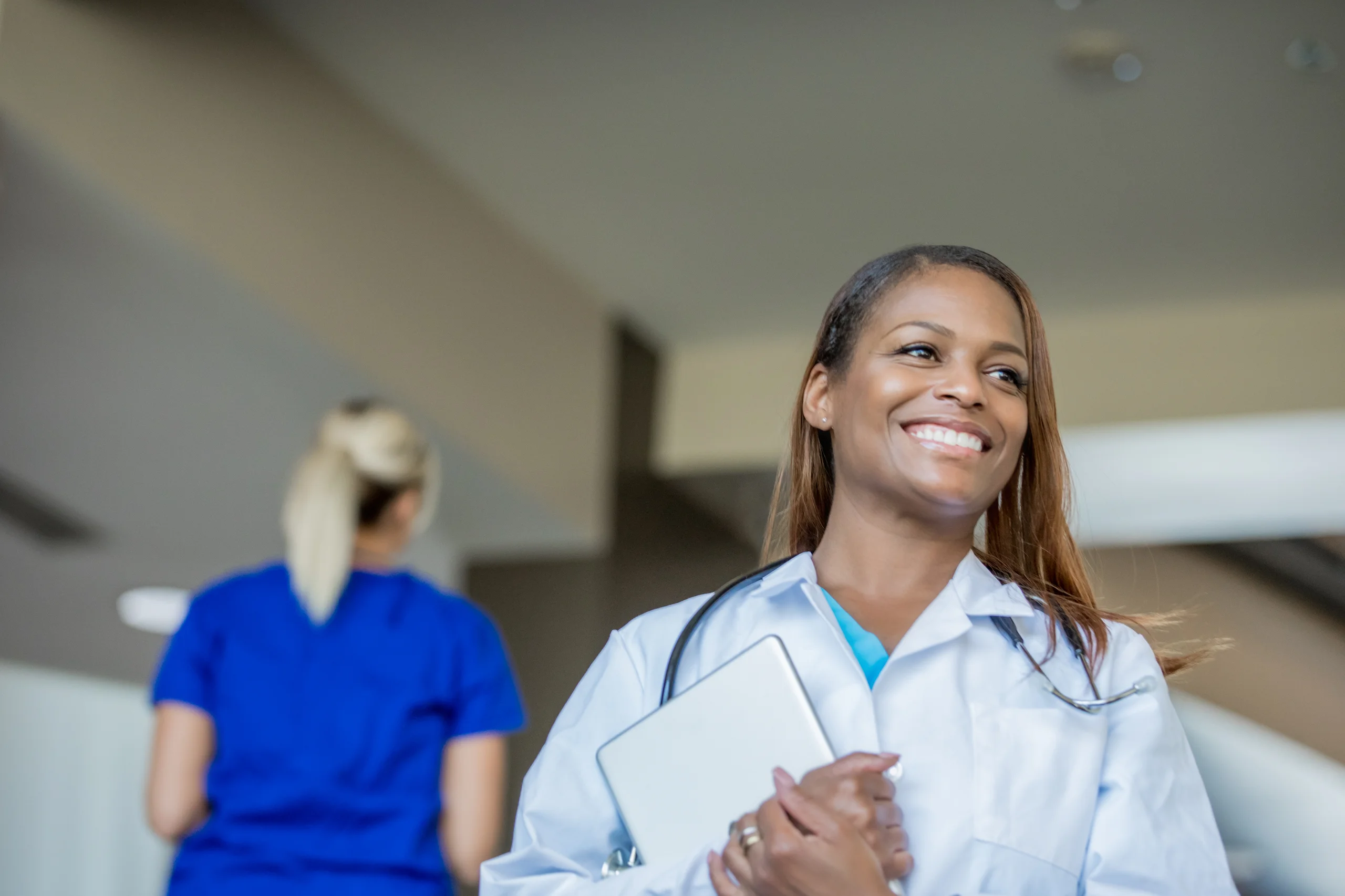 Enfermeira sorridente segurando um tablet em ambiente hospitalar