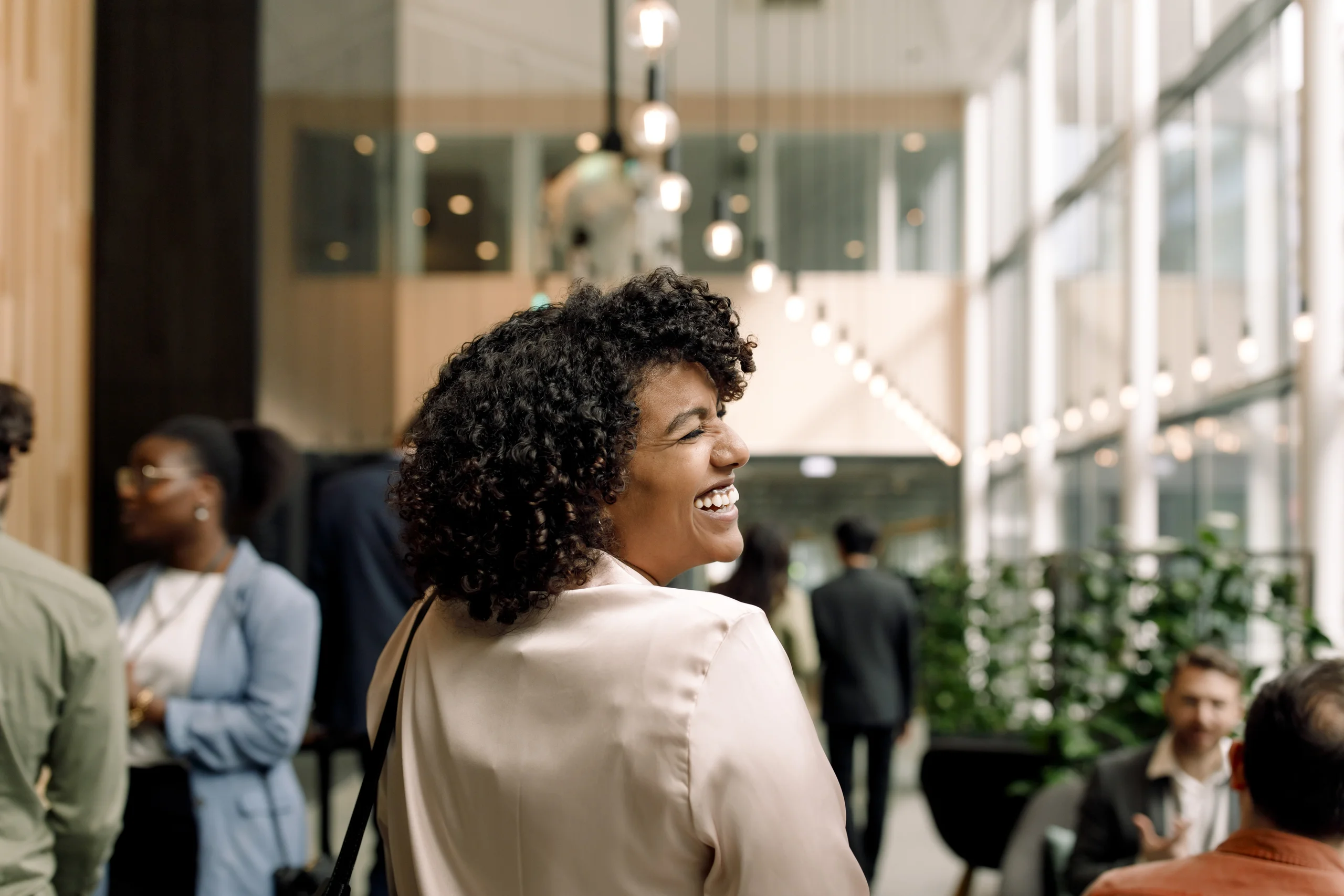Mulher sorridente em ambiente corporativo moderno representando relações internacionais