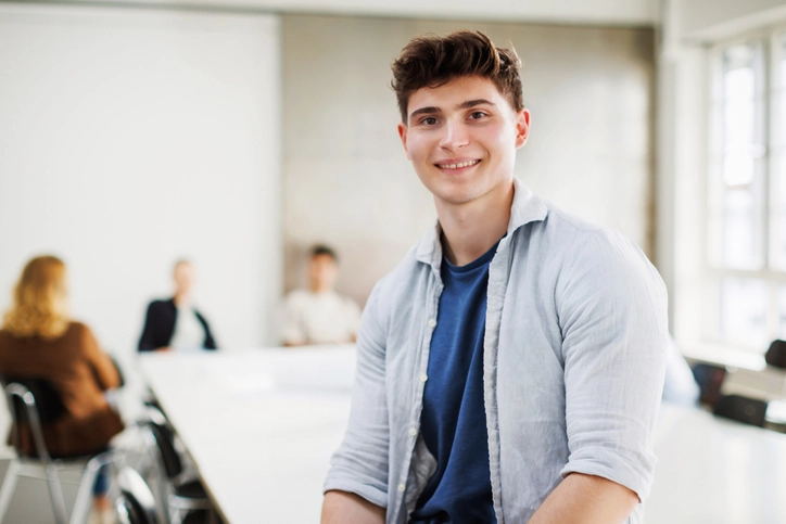 Jovem estudante universitário em ambiente acadêmico colaborativo focado no sucesso do aprendizado