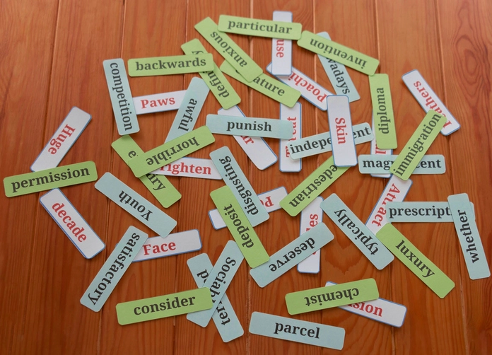 Cartões com palavras em inglês espalhados sobre uma superfície de madeira para estudo de vocabulário