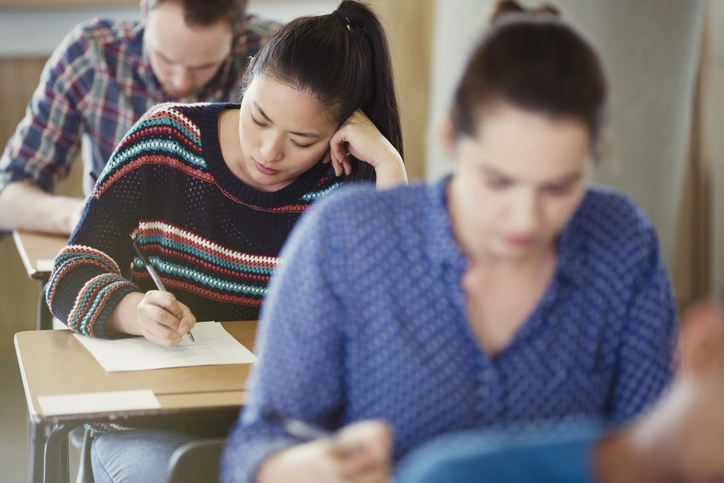 Estudantes concentrados realizando uma prova em uma sala de aula
