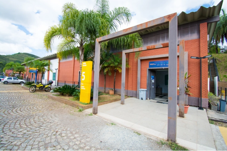 Fachada do Prédio 5 do campus universitário com tijolos aparentes e paisagismo