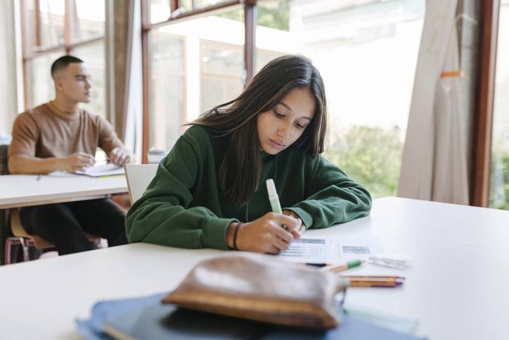 Alunos universitários dedicados estudando individualmente em ambiente acadêmico moderno para melhorar o desempenho escolar