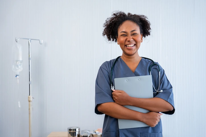Enfermeira sorridente segurando uma prancheta em um ambiente hospitalar