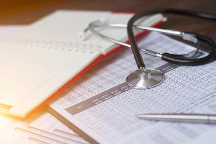 Estetoscópio sobre documentos de análise de dados médicos e caderno em uma mesa