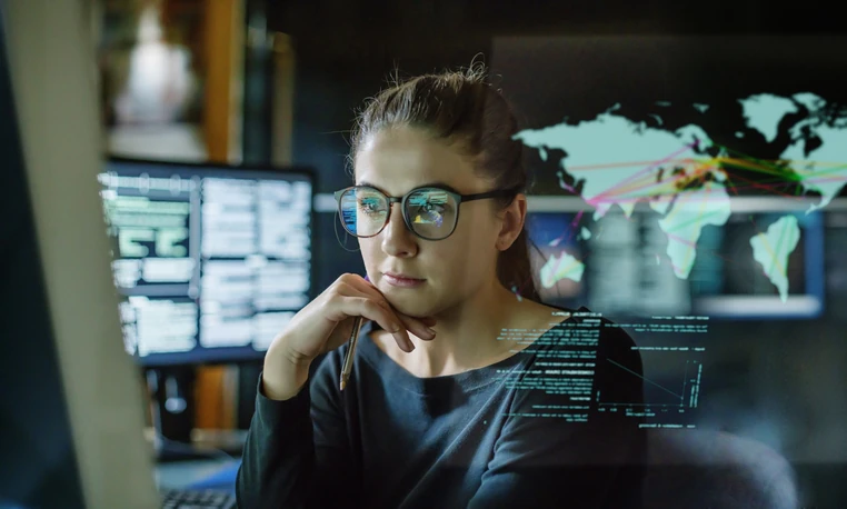 Profissional de tecnologia analisando dados complexos e redes globais em ambiente de trabalho digital moderno