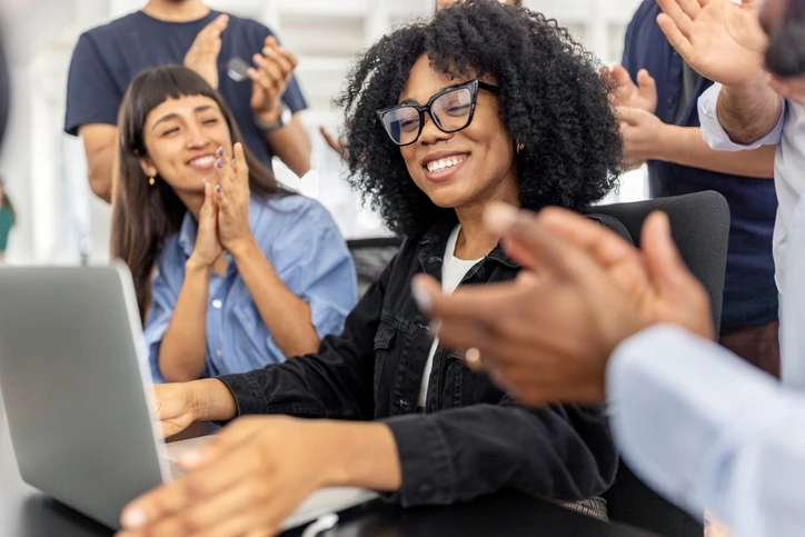 Equipe profissional diversa comemorando conquistas e sucesso no ambiente de trabalho corporativo