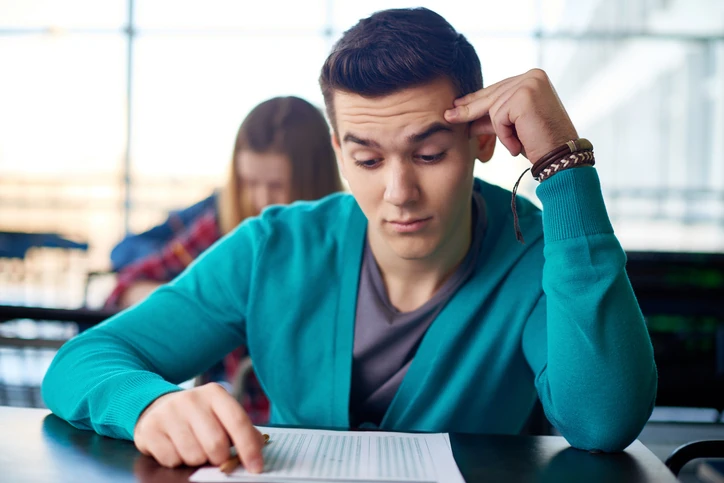 Estudante universitário focado na resolução de uma prova importante em ambiente escolar