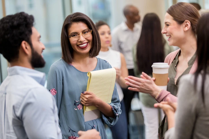 Equipe de profissionais diversos em momento de networking e colaboração em um ambiente corporativo moderno Grupo de jovens profissionais conversando e interagindo em um ambiente de escritório colaborativo