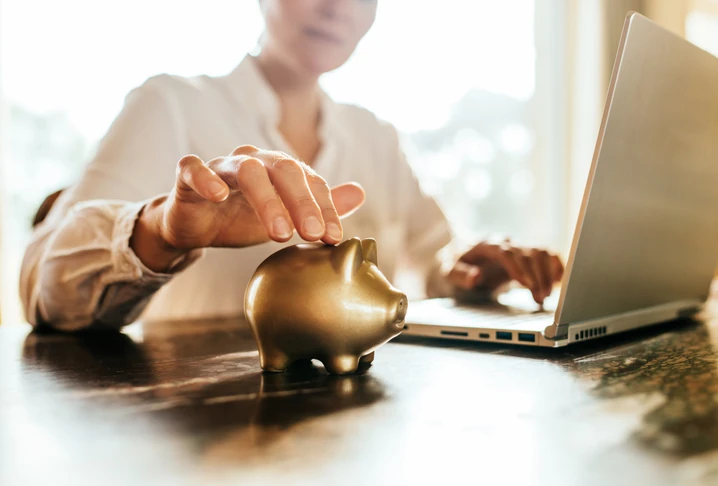 https://estaticos.animaeducacao.com.br/medias/20260116193932/GettyImages-2179166478.webp Planejamento financeiro e investimentos digitais: pessoa poupando dinheiro com cofrinho enquanto utiliza computador