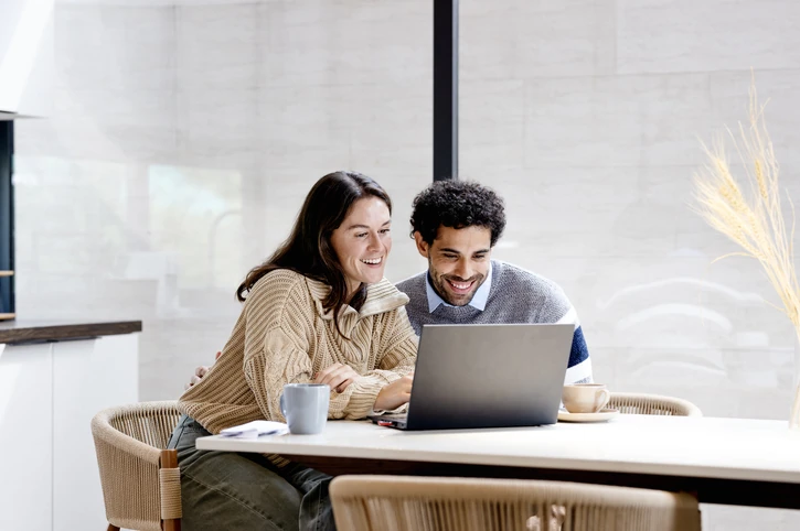 https://estaticos.animaeducacao.com.br/medias/20260116203136/GettyImages-2185166410.webp Casal jovem e feliz utilizando computador portátil para estudos ou trabalho em ambiente doméstico aconchegante