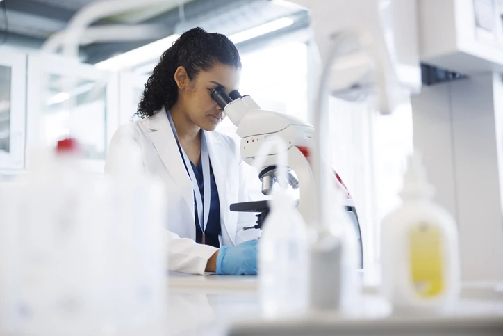 Cientista realizando pesquisa laboratorial avançada utilizando um microscópio moderno para análises científicas Pesquisadora científica trabalhando com microscópio em um laboratório de análises clínicas
