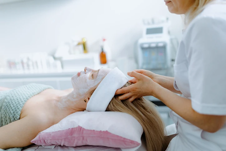 Mulher recebendo tratamento facial relaxante com máscara em uma clínica de estética