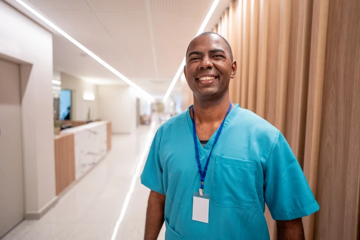 Enfermeiro sorrindo em um corredor de hospital moderno