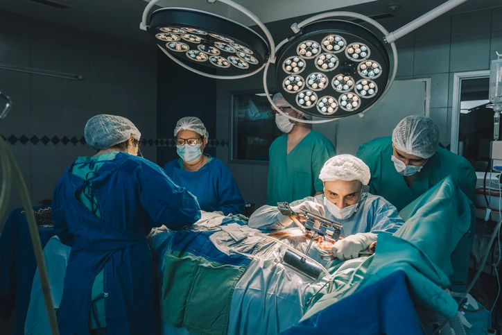 Equipe de cirurgiões e enfermeiros realizando procedimento médico complexo em um centro cirúrgico moderno e equipado