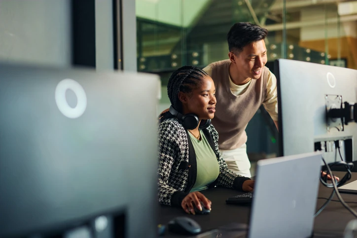 Colaboração profissional: equipe jovem trabalhando junta em projetos digitais no ambiente de escritório corporativo