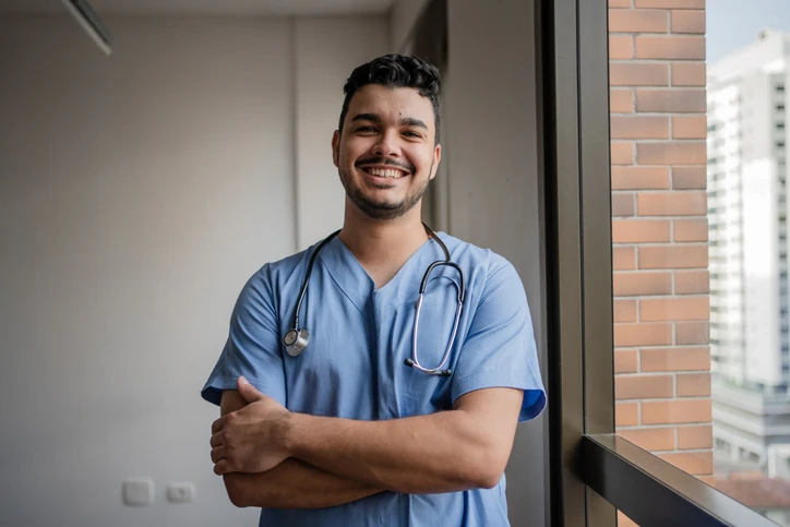 Profissional de saúde, médico ou enfermeiro, sorrindo e confiante em ambiente hospitalar